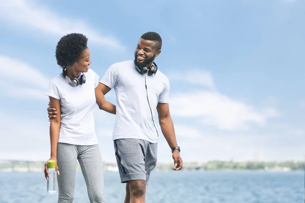 Cónyuges afroamericanos abrazando caminar después de correr cerca de río —  Fotos de Stock