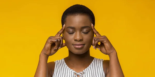 African american woman thinking hard with eyes closed