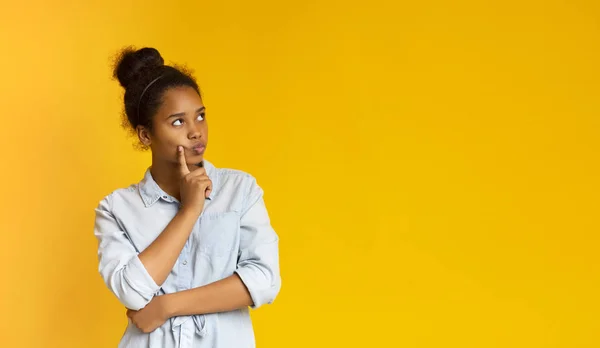 Menina adolescente pensativo posando sobre fundo amarelo — Fotografia de Stock