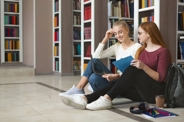 Όμορφες έφηβες φιλενάδες που σπουδάζουν στο πάτωμα στη βιβλιοθήκη — Φωτογραφία Αρχείου