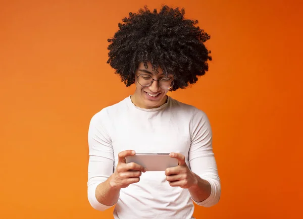 Joven alegre viendo vídeo en el teléfono celular —  Fotos de Stock