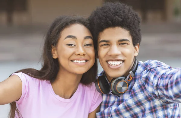 Twee vrolijke Afrikaanse tieners die selfie buitenshuis maken — Stockfoto