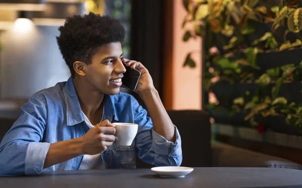Genç afro adam cep telefonu konuşuyor ve gülümseyerek