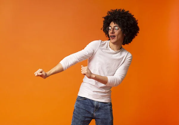 Alegre hombre negro espeso bailando sobre fondo naranja —  Fotos de Stock