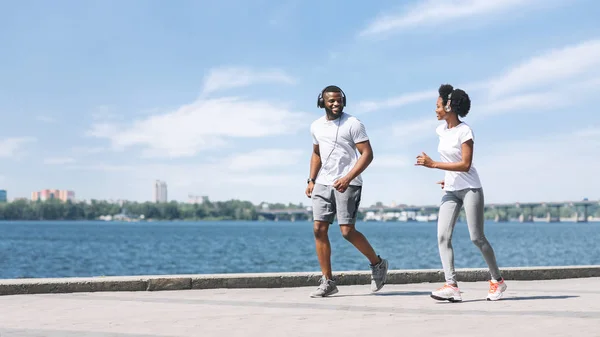 Pozitivní muž a žena běžící podél řeky nábřeží — Stock fotografie