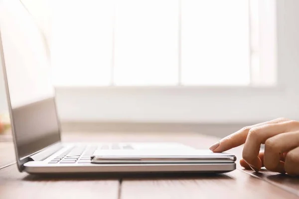 Närbild av hona med smartphone som ligger på laptop — Stockfoto