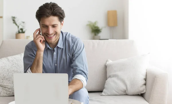 Hombre usando el ordenador portátil hablando en el teléfono celular con el operador de atención al cliente — Foto de Stock