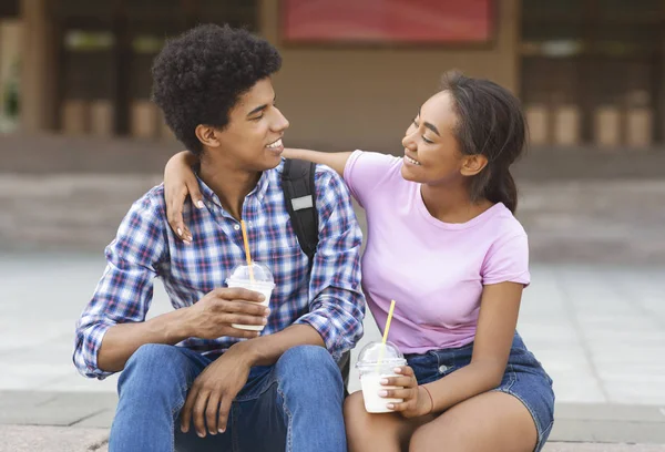 Lachende Afrikaanse tieners drinken afhaal cocktails, plezier buitenshuis — Stockfoto