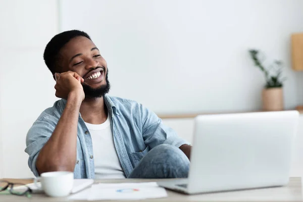 Afrikaanse kerel praten op telefoon, werken aan laptop in Office — Stockfoto