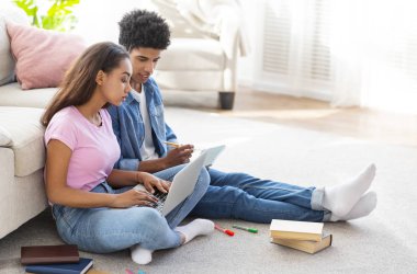 Genç Afrikalı öğrenciler evde birlikte dizüstü bilgisayar üzerinde çalışıyor