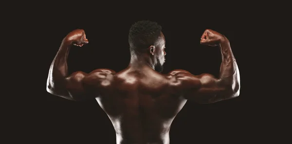 Visão traseira do modelo de aptidão afro-americano demonstrando corpo atlético — Fotografia de Stock