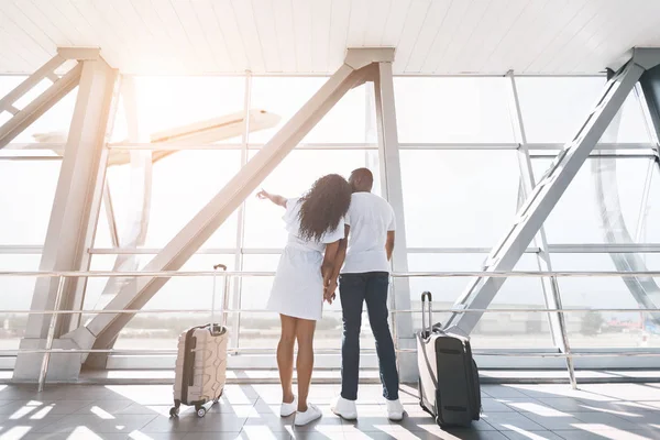 Liebespaar plant Flitterwochen, Blick auf Fenster im Flughafen — Stockfoto