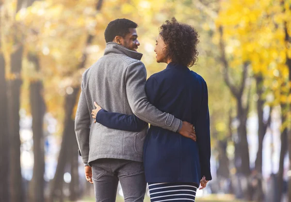 Vista trasera de la joven pareja negra acurrucándose en el bosque de otoño —  Fotos de Stock