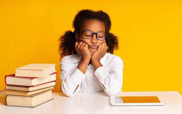 Afro Schoolgirl Sitting Between Tablet And Books On Yellow Background — Stock Photo, Image