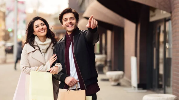 Happy couple walking with shopping purchases on autumn day — Stock Photo, Image