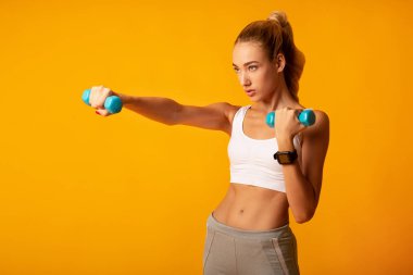 Genç Kadın Sarı Arka Plan Üzerinde Dumbbell Boks Egzersiz yapıyor