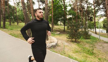 Yakışıklı bin yıllık adam açık havada kardiyo eğitim sahip