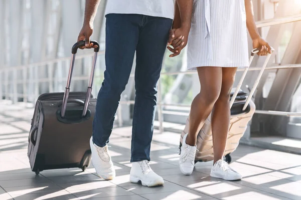 Чорношкіра пара тисячоліть, що ходить з багажем у будівлі аеропорту — стокове фото