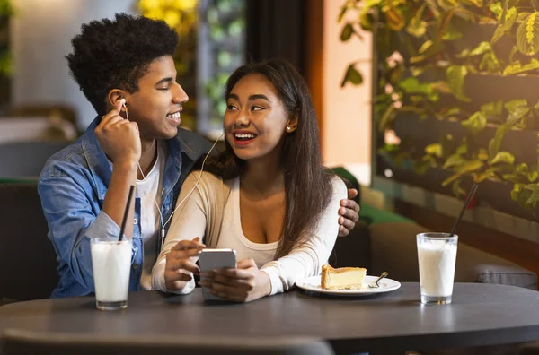 Gelukkige tieners luisteren naar muziek op telefoon — Stockfoto