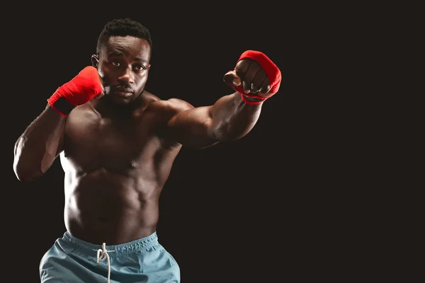 Boxeador africano enfocado luchando sobre fondo negro — Foto de Stock