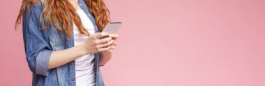Cool Uygulama. Redhead Kız Pembe Arka Plan Üzerinde Smartphone kullanma