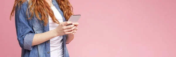 Aplicación genial. Pelirroja chica usando Smartphone en rosa fondo — Foto de Stock