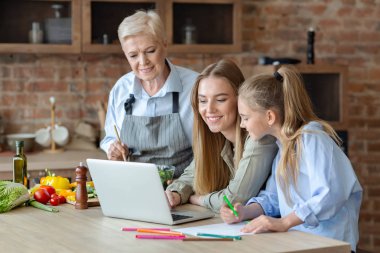 Kız, anne ve büyükanne yemek yaparken eğleniyor