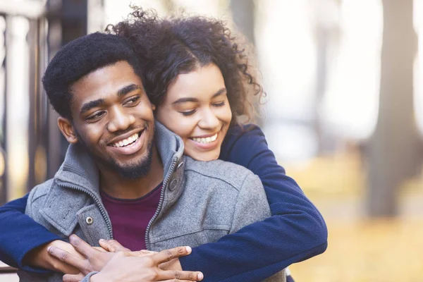 Lovely black couple cuddling while date in autumn park — Stock Photo, Image