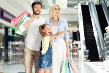 Alışveriş Merkezinde Ailesiyle Yürüyen Bir Şeyi İşaret Eden Kız