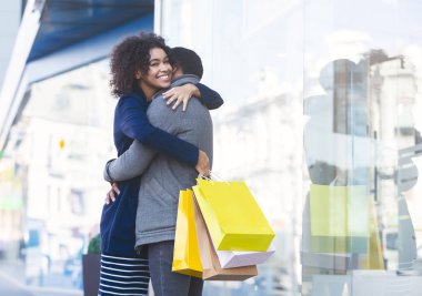 Alışveriş merkezinin yanındaki alışveriş poşetleriyle sarılan genç aşıklar