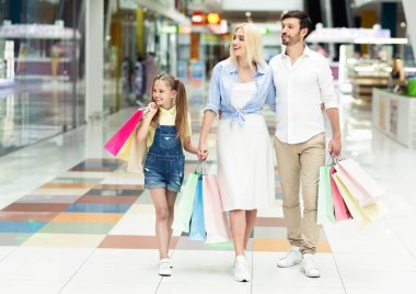 Alışveriş merkezinde alışveriş yaptıktan sonra birlikte zaman geçiren aile