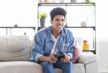 Joystick kullanarak evde video oyunları oynayan mutlu genç adam