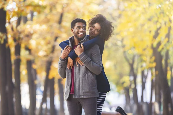 Carino nero ragazza salto su fidanzato indietro in parco — Foto Stock