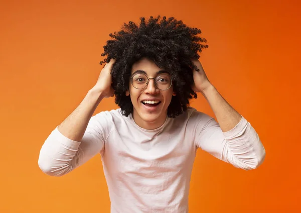 Emocional surpreendido jovem negro cara segurando seu cabelo encaracolado — Fotografia de Stock