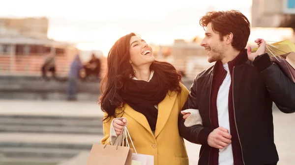 Happy couple carrying shopping bags and walking at autumn day — Stock Photo, Image