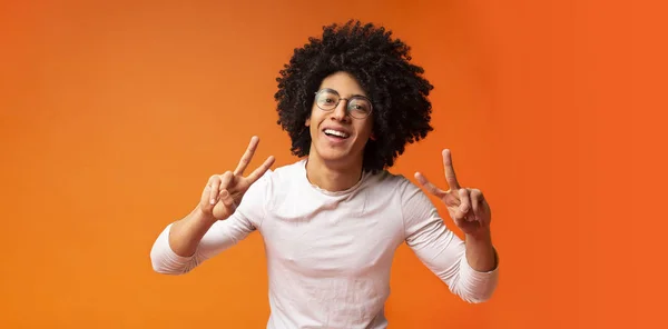 Cool afroamericano chico sonriendo y demostrando v-signos —  Fotos de Stock