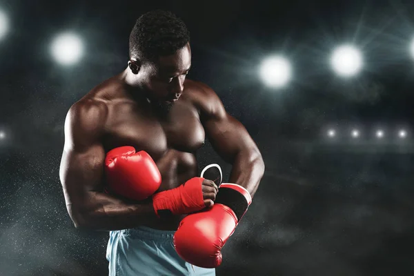 Černý boxer zůstává na boxerském prstenci, nosí červené rukavice — Stock fotografie