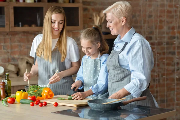 成熟した女性は、調理する方法を小さな女の子を教える — ストック写真