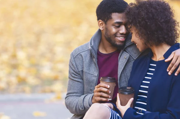 Adorable pareja afroamericana enamorada de beber café en el parque —  Fotos de Stock