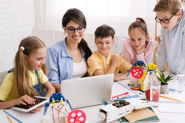 Kids learning about computers and robots with their teacher — Stock Photo, Image