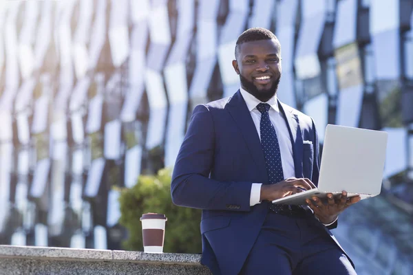 African American przedsiębiorca korzystanie laptop siedzi w obszarze miejskim — Zdjęcie stockowe