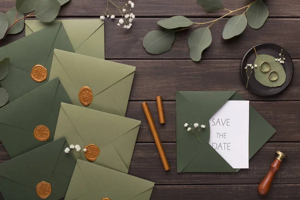 Приглашения на свадьбу сохраняют дату в зеленых конвертах — стоковое фото
