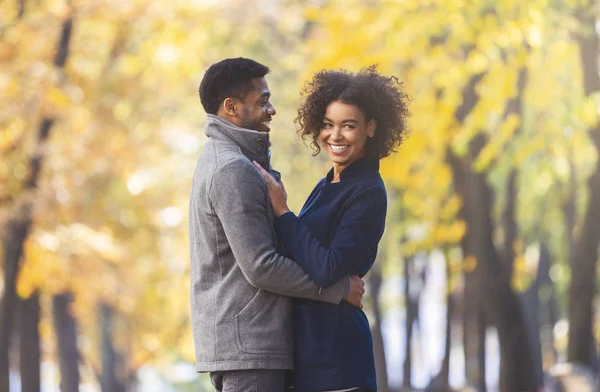 Pareja joven afroamericana acurrucándose en parque dorado —  Fotos de Stock