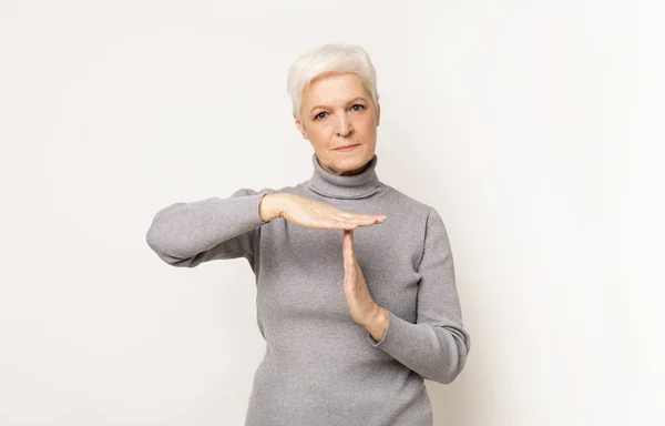 Mujer mayor impaciente haciendo tiempo fuera gesto —  Fotos de Stock