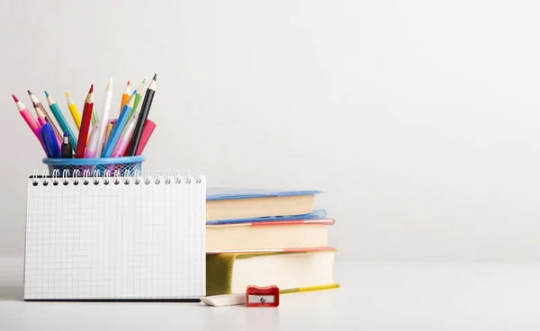 School-en kantoorbenodigdheden met boeken over witte achtergrond — Stockfoto