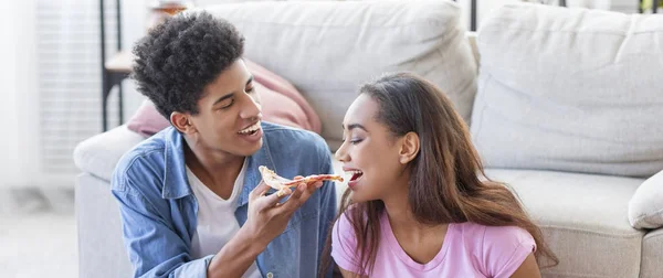 Brincalhão menina negra degustando seus namorados pizza — Fotografia de Stock