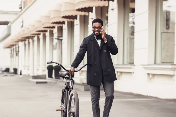 Afro-amerikansk affärsman med cykel promenader och pratar på mobiltelefon — Stockfoto