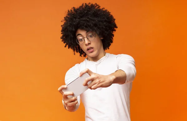 Emocional chico negro jugando videojuegos en línea en el teléfono celular —  Fotos de Stock