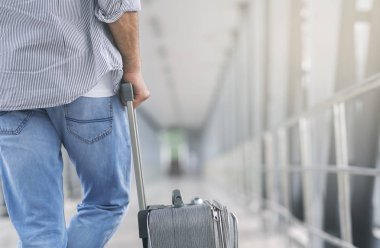 Havaalanında terminal geçitte duran bagajı olan adam