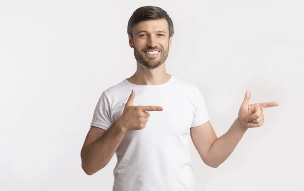 Усміхнений хлопець вказує пальці на білому тлі — стокове фото